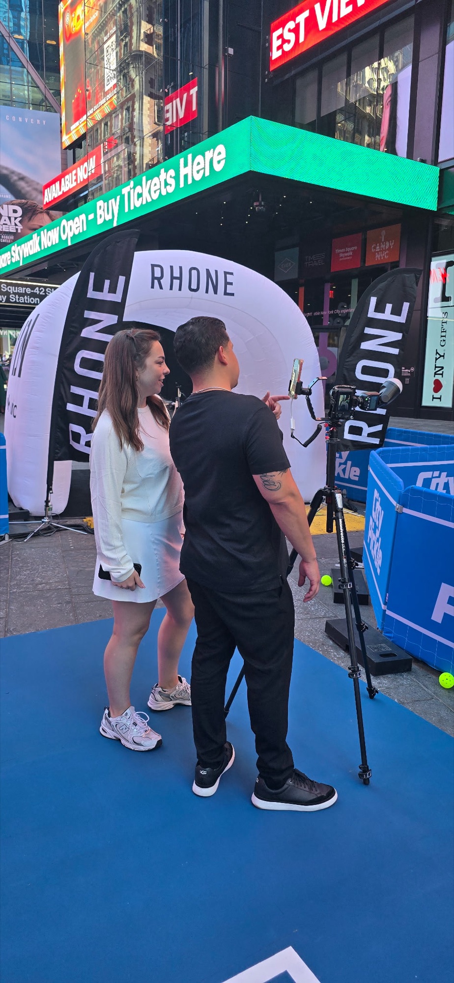 A DigiBooths roaming photographer and tablet attendant sharing a just-captured photo with a guest at the Rhone CityPicklePalooza activation in Times Square