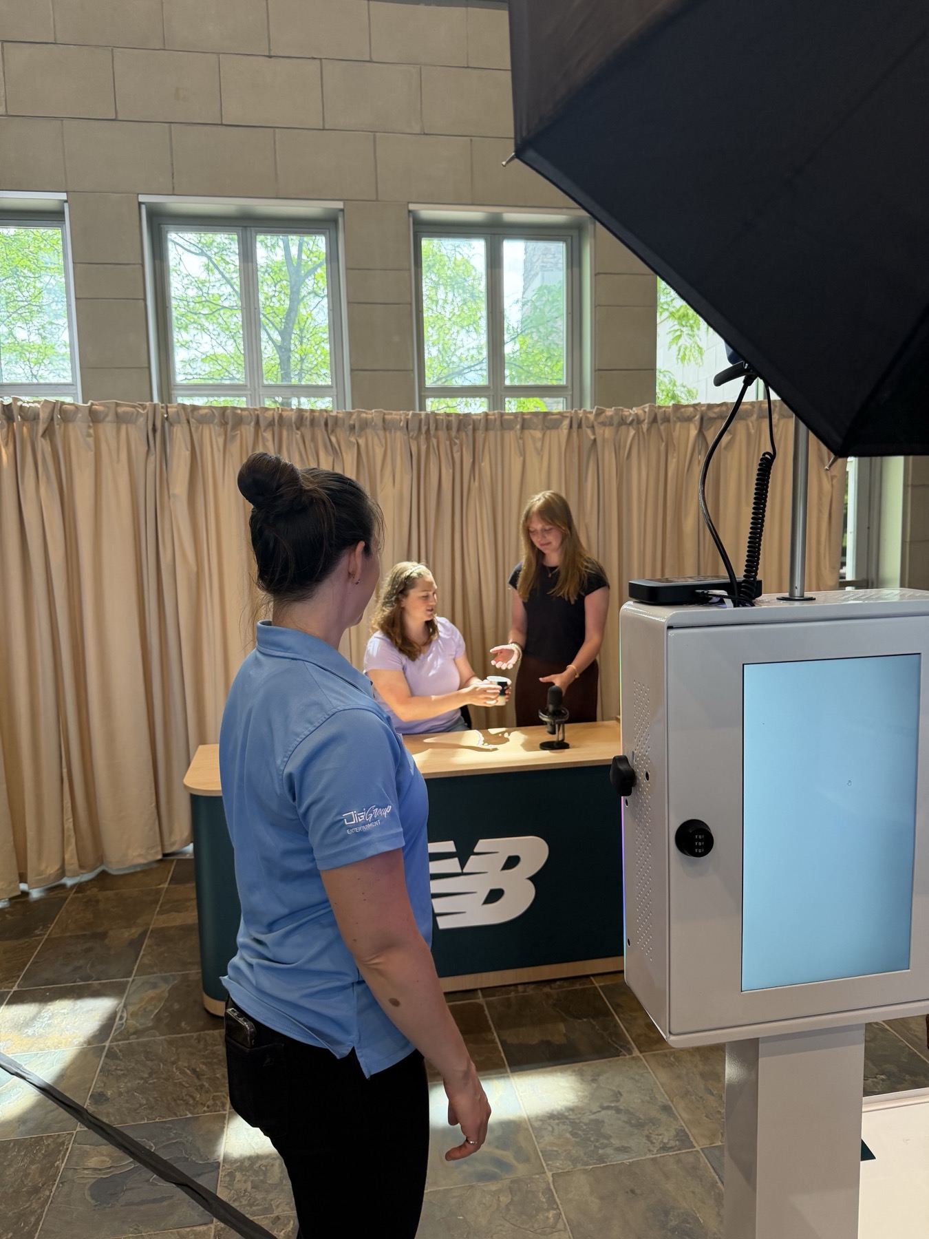 Guests engaging with a DigiGroup team member at the New Balance branded activation desk during the Dick's Sporting Goods headquarters event
