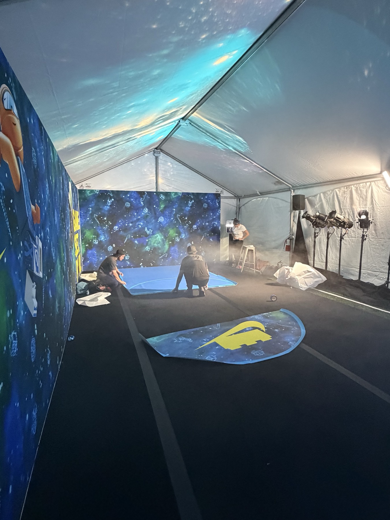 Crew building the branded galaxy-themed Nike × LEGO obstacle-course tent before the activation opens, LEGO and Nike graphics on the walls