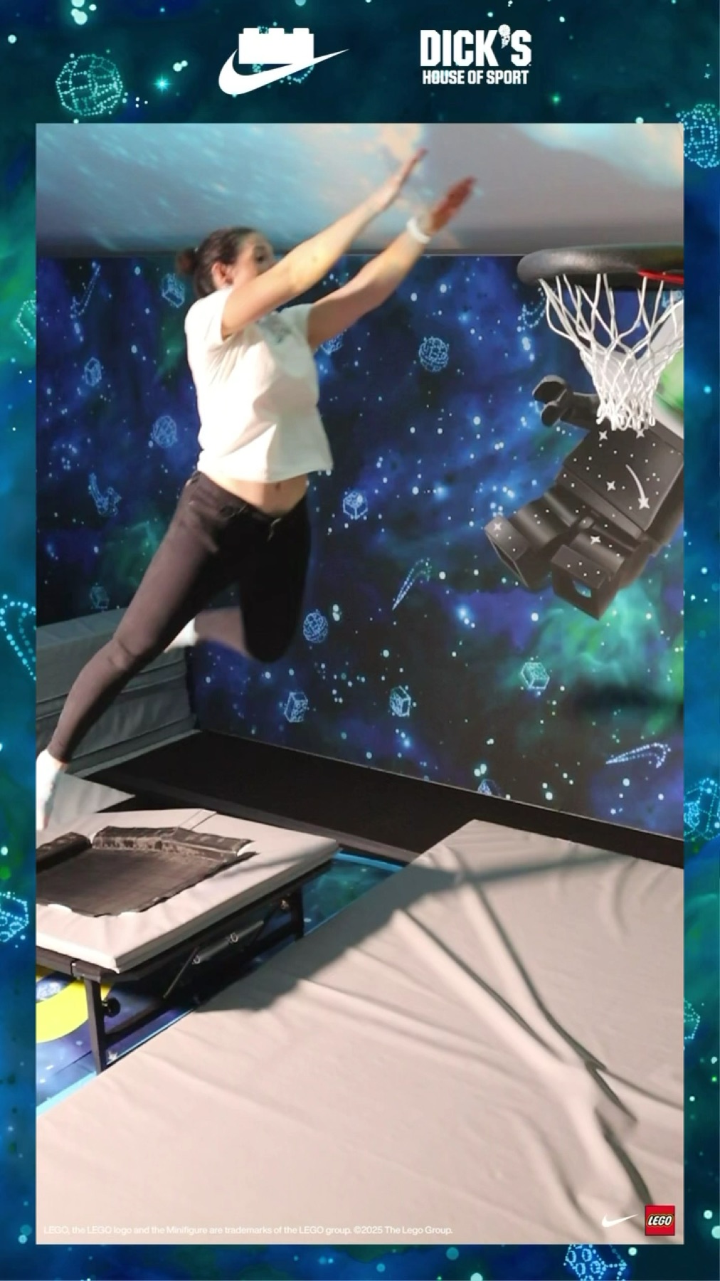 A guest mid-air completing the branded slam-dunk finish inside the galaxy-themed Nike × LEGO activation tent, Dick's House of Sport and LEGO branding on the walls