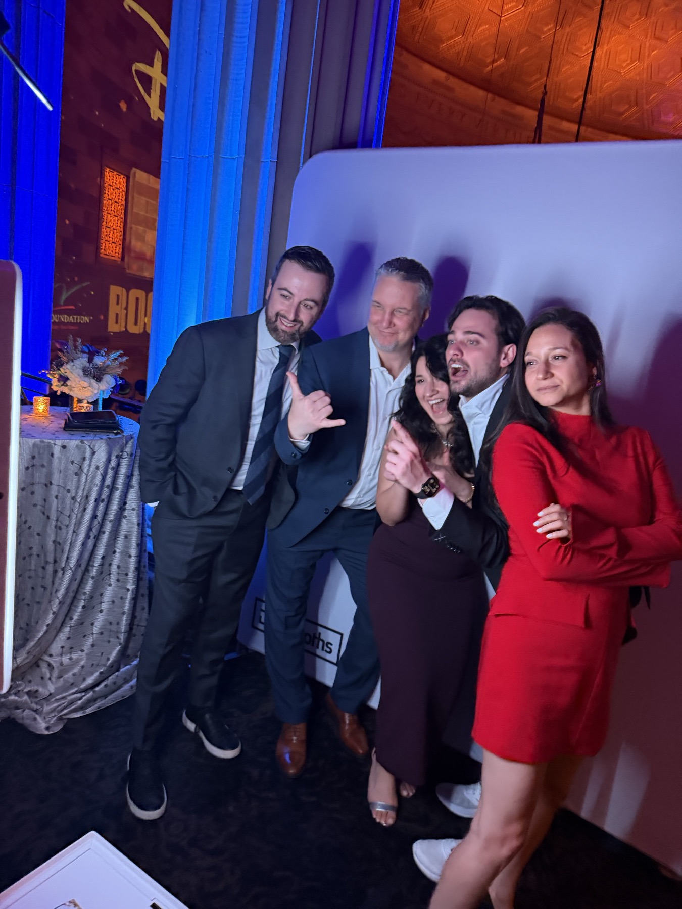 Guests posing at the DigiBooths open-air booth against the V Foundation branded backdrop in an ornate NYC ballroom