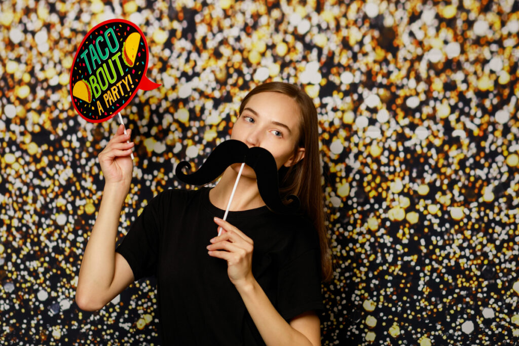 A woman enjoying herself while posing for a photo in the photo booth.