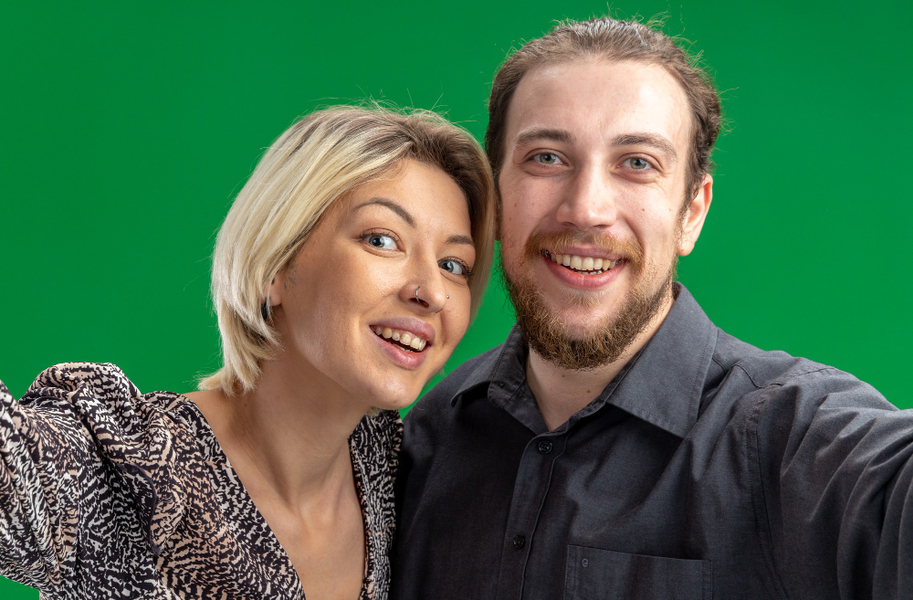 A couple taking picture via green screen background