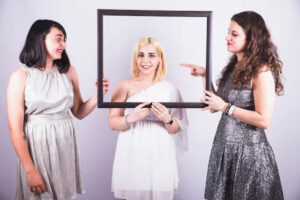 A group of friends uses frames as props in photobooth shots