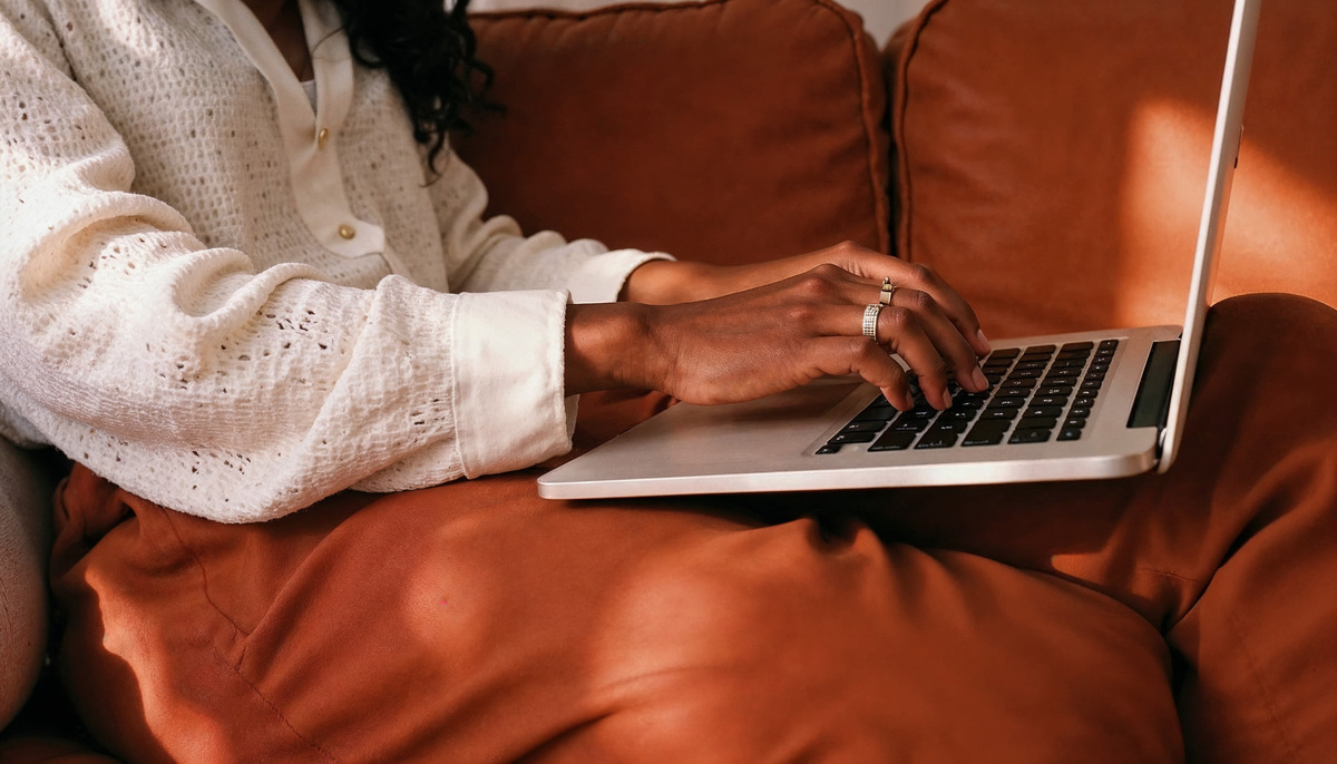 A woman using a laptop to book a photo booth.