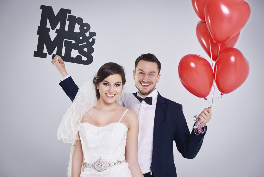 A newly married couple trying out the photo booth