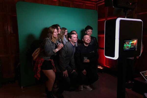 A group of friends taking a picture with an open-air photo booth