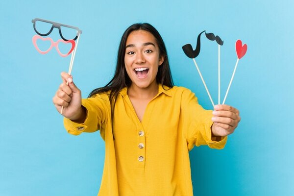 A woman holding various photo booth props