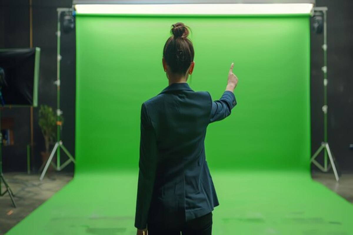 A woman setting up a green screen photo booth for the event