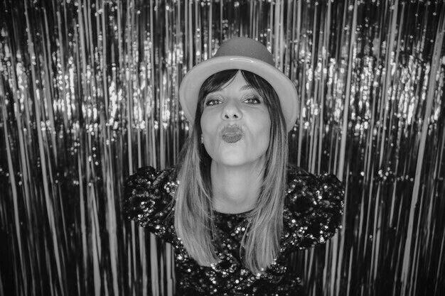 A young woman blowing a kiss in a Glam Booth