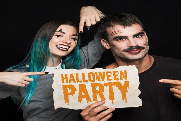 Couples holding Halloween-themed photo booth props