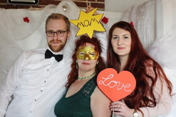 Guests enjoying taking pictures in a wedding photo booth