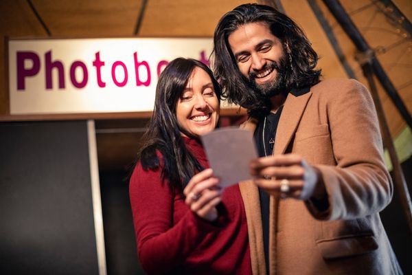 Two employees in a classic photo booth