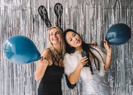 women taking a pictures in photo booth