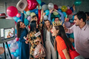 People enjoying the photo booth experience while holding photo booth props