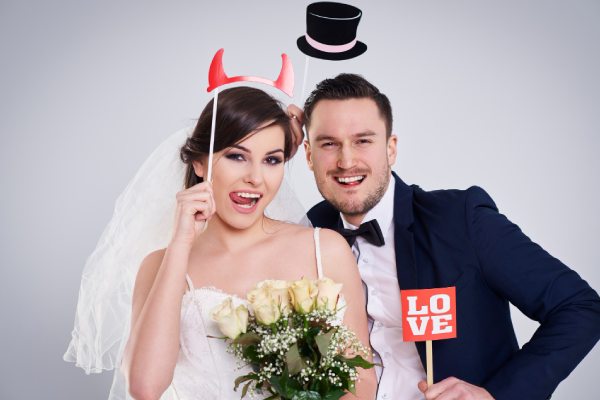 bride and bridegroom making funny faces in photo booth