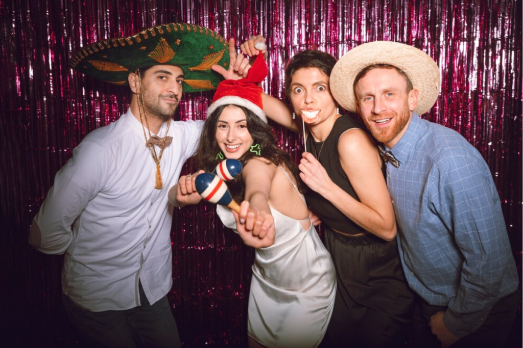 Group of people using various props in a photo booth
