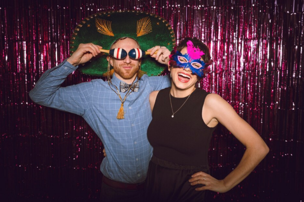 Couple wearing playful props in a photo booth