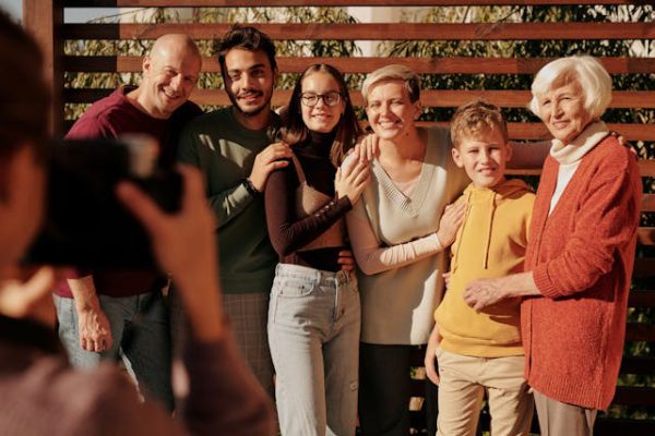 smiling family posing for a reunion photo moment in natural sunlight