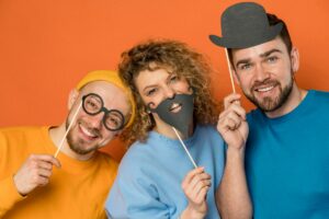 three family members posing with playful props in a photo booth at a reunion event
