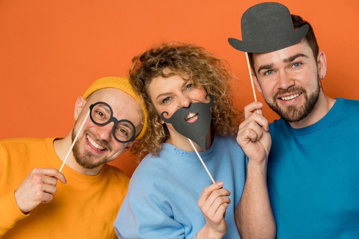 three family members posing with playful props in a photo booth at a reunion event